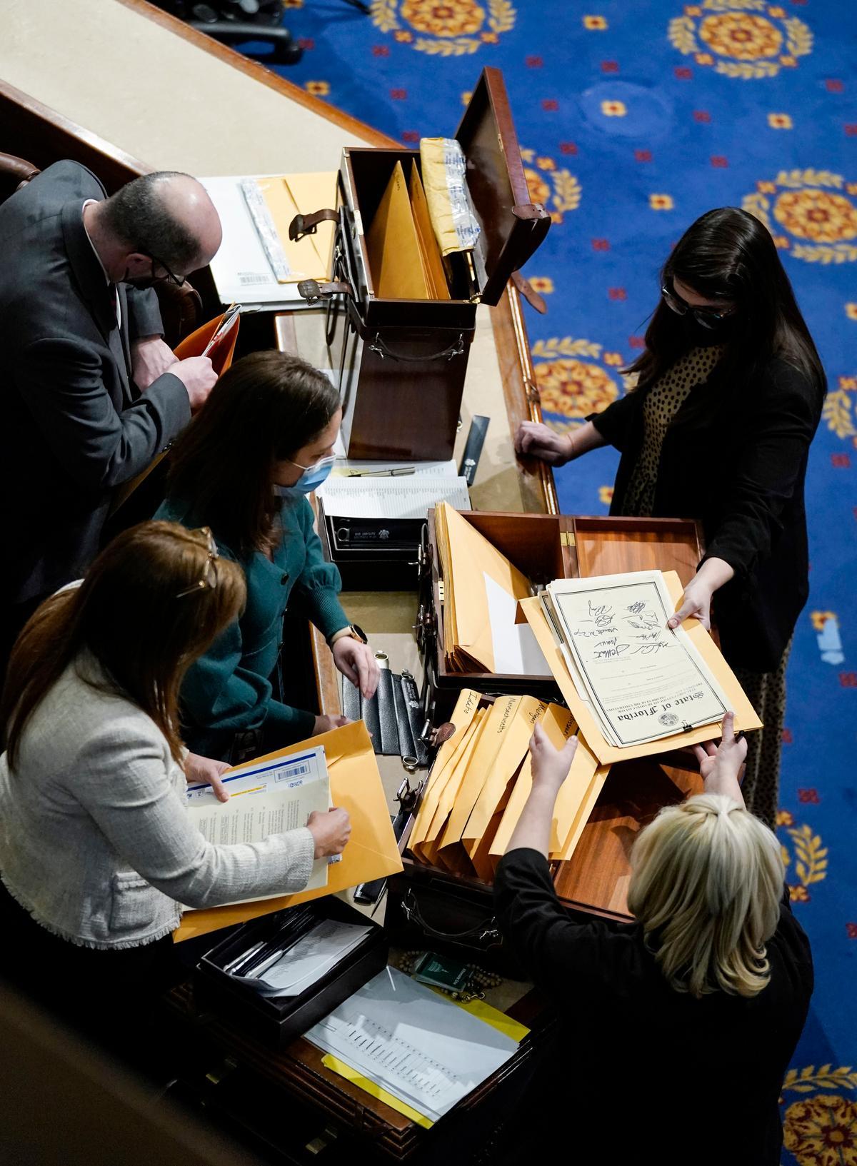 Congressional aides examine electoral college votes in the House Chamber during a reconvening of a joint session of Congress in Washington on Jan. 6, 2021. (Drew Angerer/Getty Images)