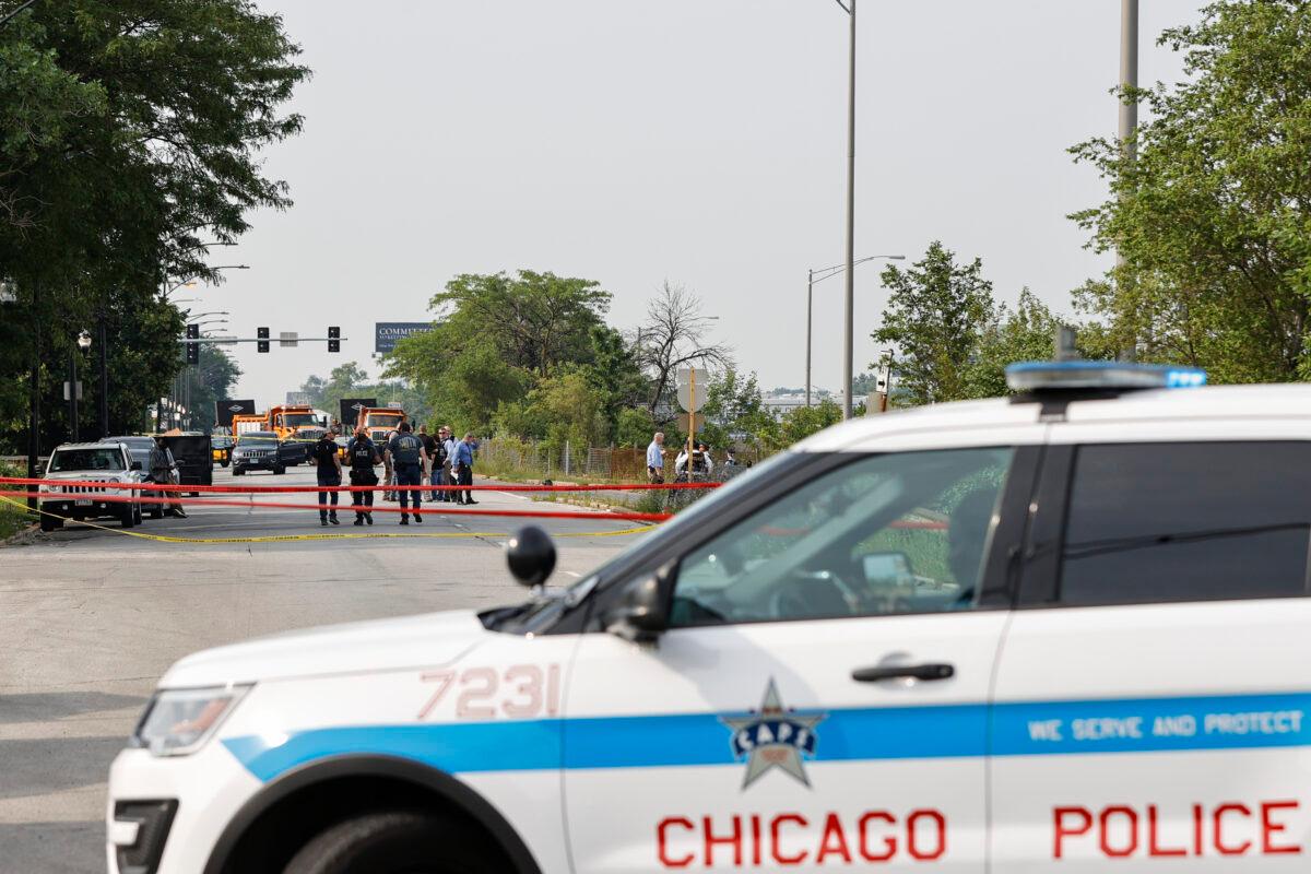 Law enforcement officers investigate the crime scene near the border between the Morgan Park and West Pullman neighborhoods in Chicago, Ill., on July 7, 2021. (Kamil Krzaczynski/Getty Images)