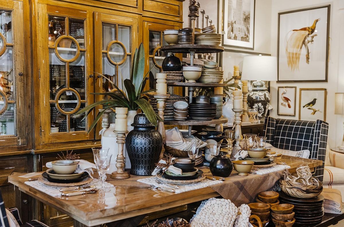 Stacks of earthenware atop a wooden table are grounded by a glass door cabinet full of coordinating accessories. (Handout/TNS)