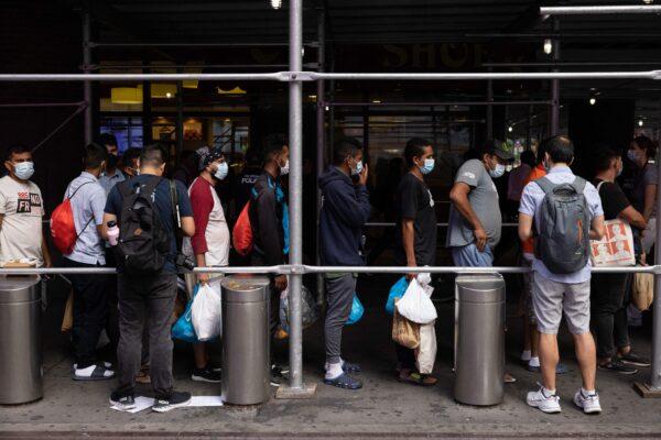 A group of migrants from Texas wait in line outside Port Authority Bus Terminal to receive humanitarian assistance in New York on Aug. 10, 2022. (Yuki Iwamura/AFP via Getty Images)