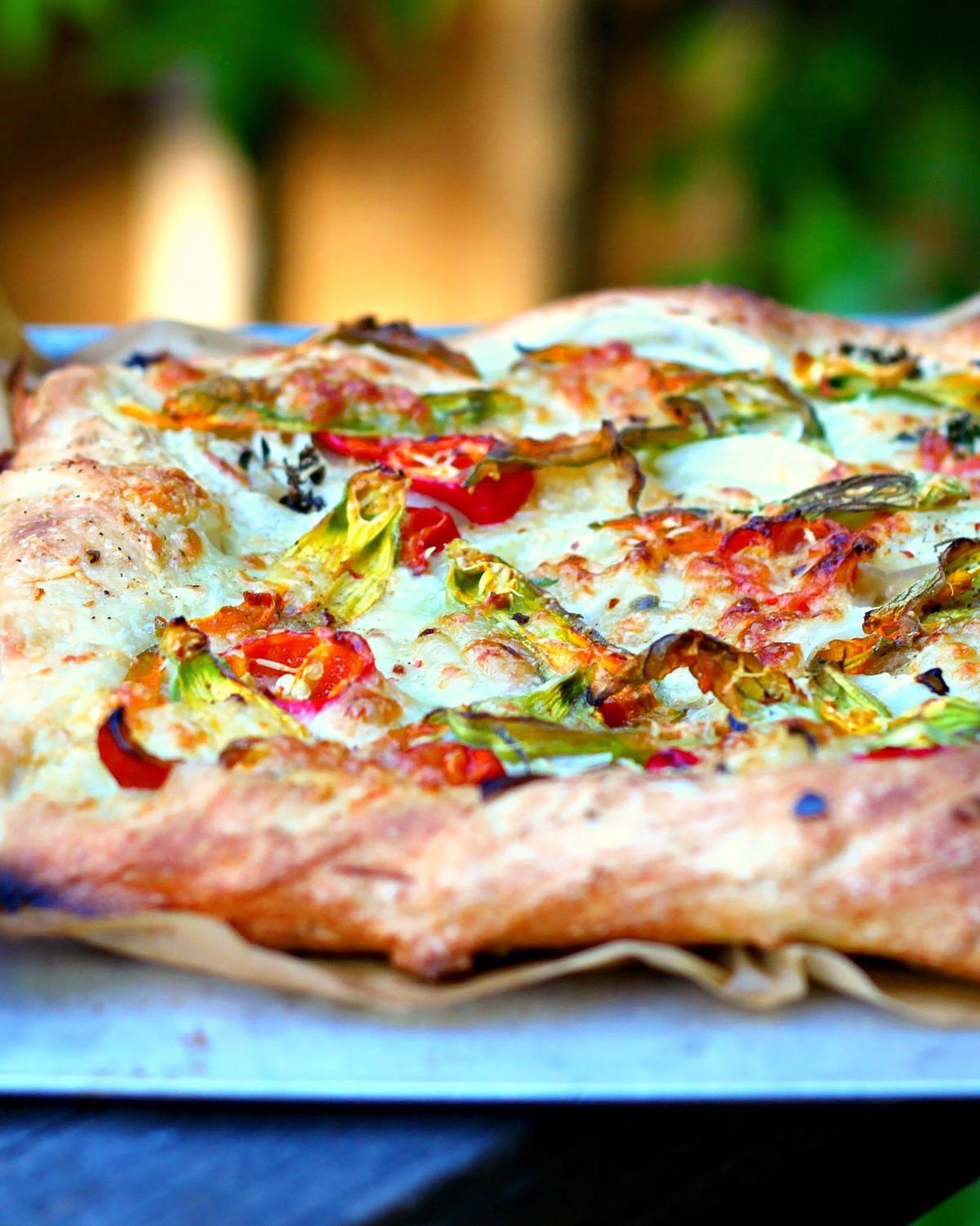 The zucchini flowers will shrivel and char while roasting, creating a colorful, textural topping for this pizza. (Lynda Balslev for Tastefood)