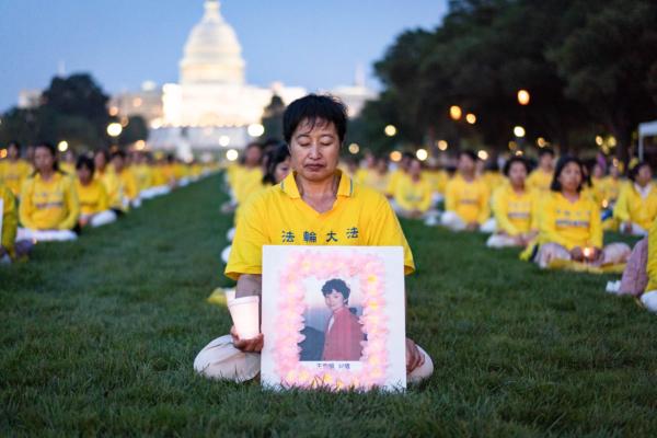  Falun Gong adherents take part in a candlelight vigil in memory of Falun Gong practitioners who have died because of the Chinese Communist Party’s 24 years of persecution, at the National Mall in Washington on July 20, 2023. (Samira Bouaou/The Epoch Times)