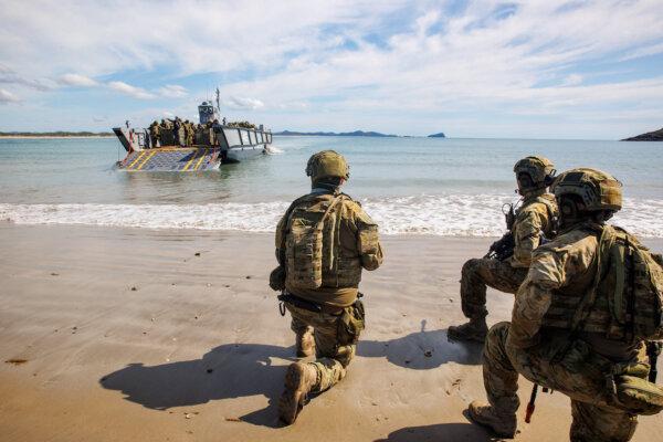 Australian Army soldiers from the 10th Force Support Battalion's Amphibious Beaching Team await the arrival of troops on a Lighter Landing Craft during Exercise Trident 2022 near Shoalwater Bay Training Area, Queensland. (Courtesy of the Australian Defence Force)