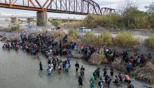 Migrants wait in the Rio Grande for an opening in the razor wire barrier to cross into the United States in Eagle Pass, Texas, on Sept. 25, 2023. (Andrew Caballero-Reynolds/AFP via Getty Images)