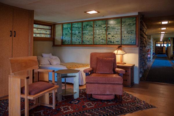The windows in Frank Lloyd Wright’s simple, twin-bed bedroom provided him with a view of the surrounding valley and the hill gardens that he had experienced during childhood. Throughout the house are several prototype chairs from various projects, including the bedroom’s clean-lined wooden chair with an upholstered seat. Paneled Asian-inspired art is the room’s only adornment, other than the hand-woven rug and another of Wright’s unique table lamp designs. (Courtesy of Taliesin Preservation)