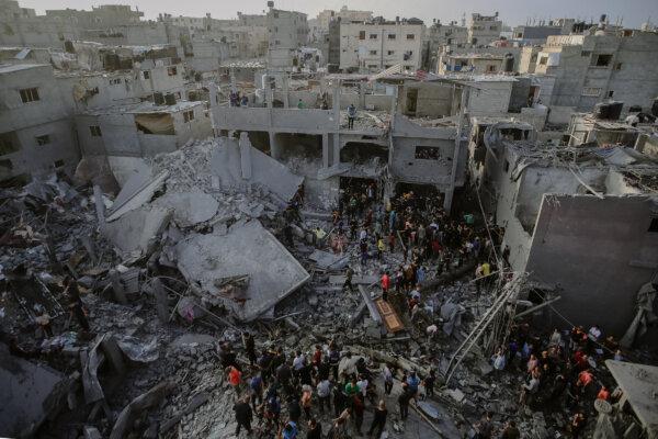 Palestinian civilians and rescue teams sifting through the debris of a collapsed building in Al-Maghazi, located in the central Gaza Strip, in search of survivors and victims following the Israeli bombardment on Nov. 5, 2023. (Mohammed Zaanoun/Middle East Images/AFP via Getty Images)