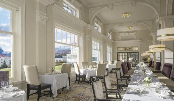 Flowing from the main dining room is the Sun Dining Room. Despite various updates over the years, this space has retained the Italian hand-plastered, leaf-design work at the top of the columns as well as moldings over window pediments and corners of ceiling arches. The art-glass transom theme is carried into this spacious room, and the large leaded-glass windows with vertical transoms afford guests clear views of the outdoors. (Courtesy of the Mount Washington Hotel)