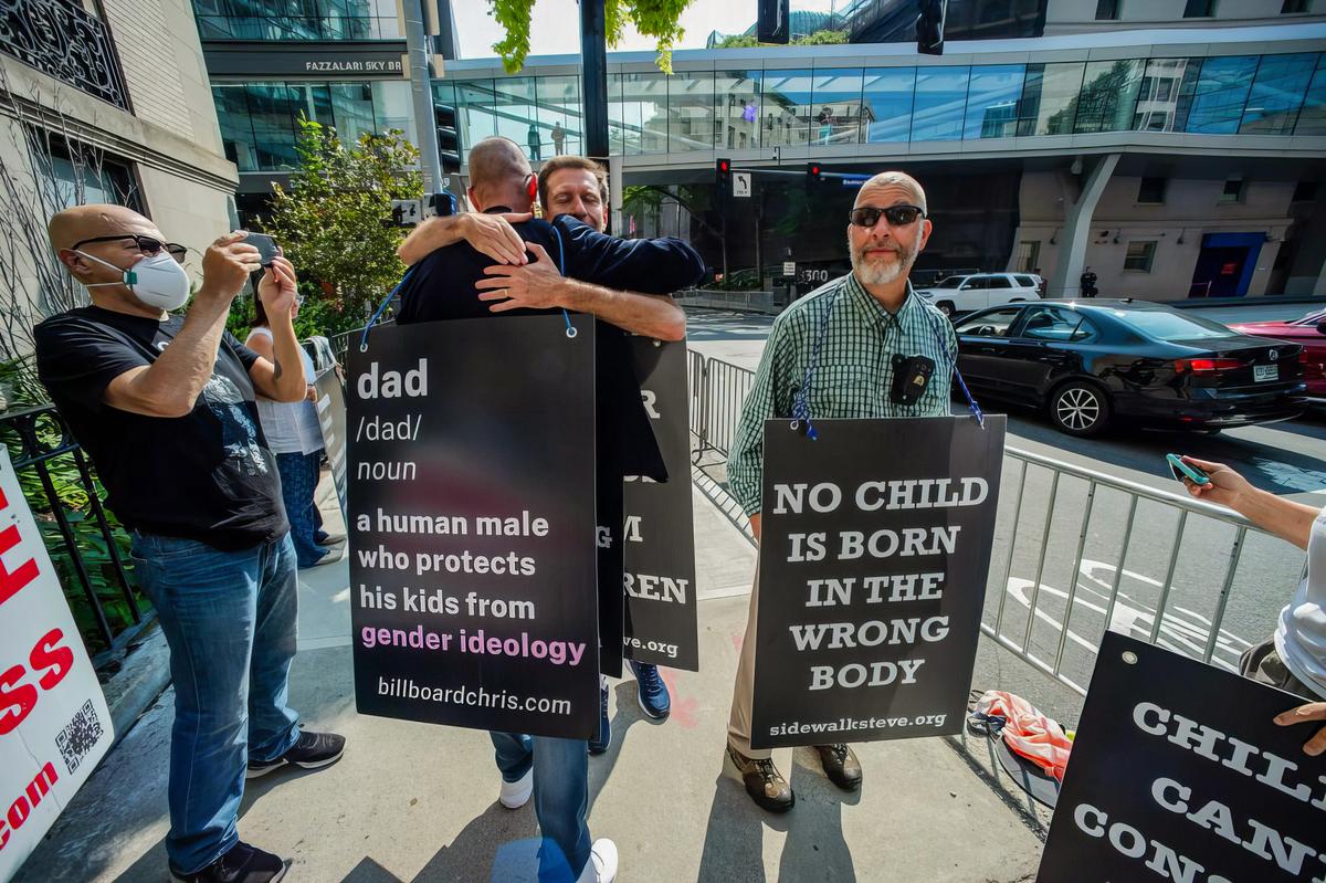  Activist Chris Elston, known as Billboard Chris (2nd L), embraces a supporter as he demonstrates against “gender-affirming” treatments and surgeries on minors, outside of Boston Children’s Hospital in Boston on Sept. 18, 2022. (Joseph Prezioso/AFP via Getty Images)