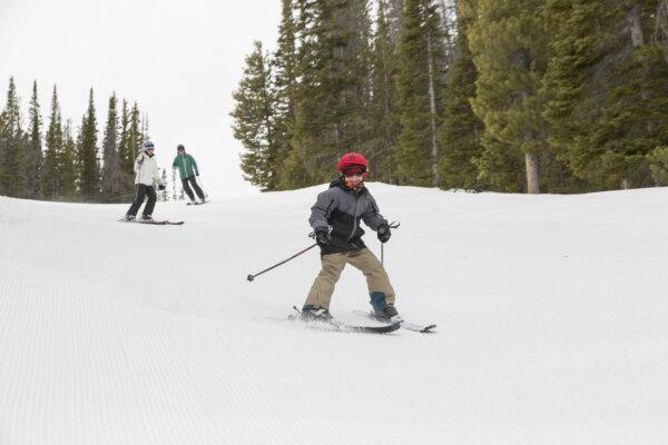  A young skier tries out a Wyoming mountain while his parents look on. (Photo courtesy of Visit Laramie)