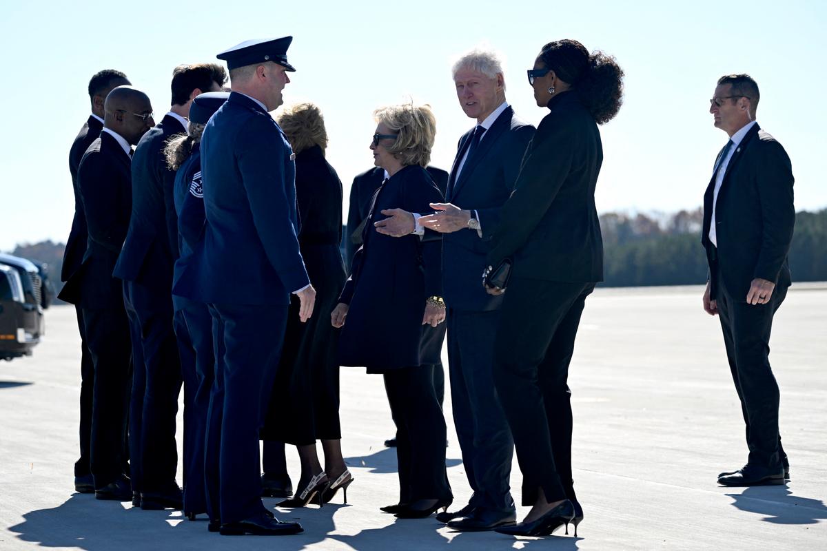 (L-R) Former Secretary of State Hillary Clinton, former President Bill Clinton, and former First Lady Michelle Obama are greeted upon arrival at Dobbins Air Reserve Base in Marietta, Georgia, on Nov. 28, 2023, as they arrive to attend a tribute service for former First Lady Rosalyn Carter. (Andrew Caballero-Reynolds / AFP)