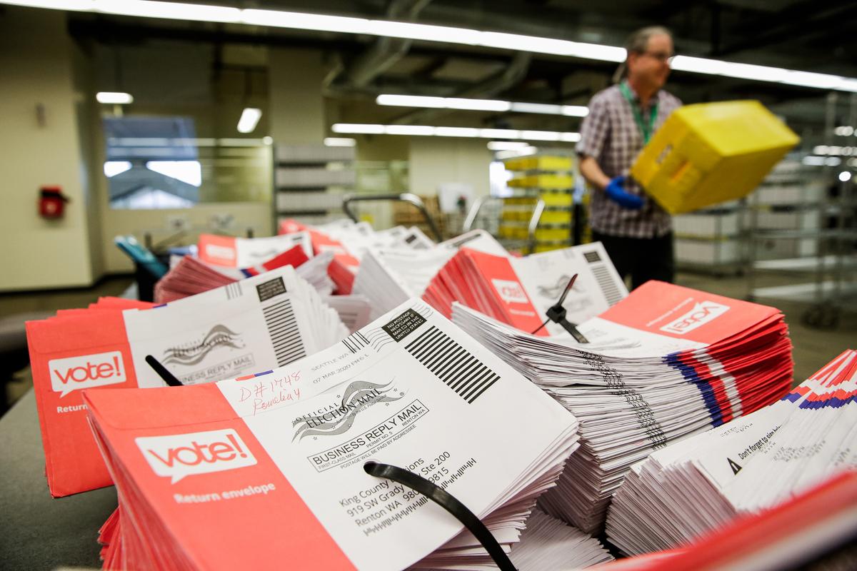 Empty envelopes of opened vote-by-mail ballots for the presidential primary are stacked on a table at King County Elections in Renton, Wash., on March 10, 2020. (JASON REDMOND/AFP via Getty Images)