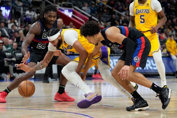 Detroit Pistons guard Cade Cunningham (2) and Los Angeles Lakers forward Anthony Davis (3) chase the loose ball during the first half of an NBA basketball game in Detroit on Nov. 29, 2023. (Carlos Osorio/AP Photo)