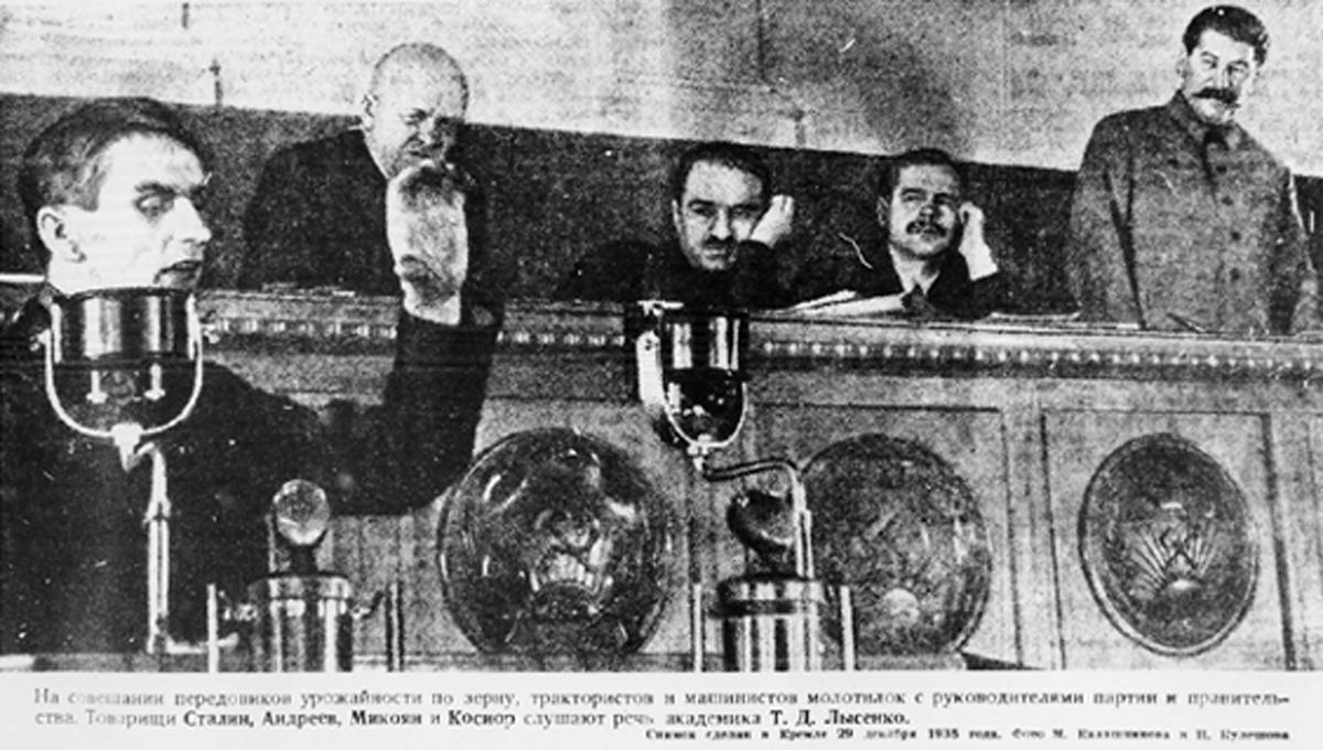 Trofim Lysenko speaks at the Kremlin in 1935. Behind him are (L–R) Stanislav Kosior, Anastas Mikoyan, Andrei Andreev, and Soviet leader Joseph Stalin.