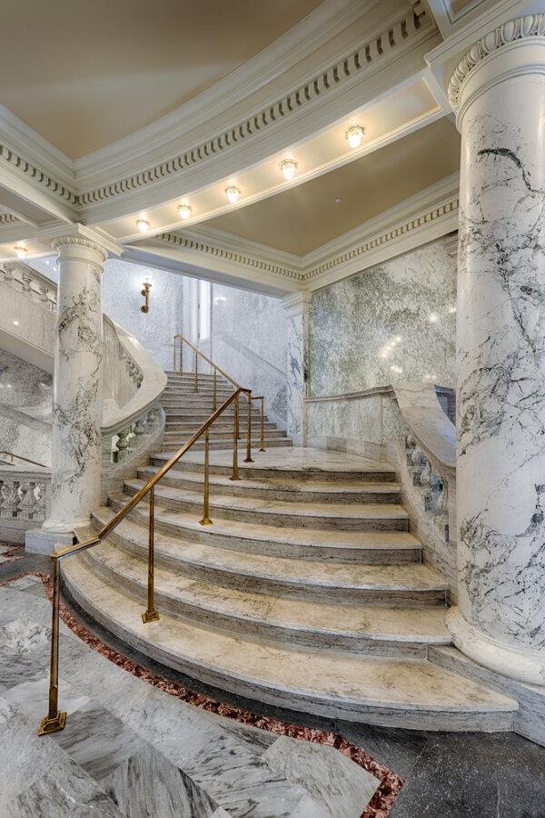 While all types of marble are plenteous throughout the structure, the effect of dramatic columns set against marble flooring provides a grand and sweeping presence in the entryway and on additional floors. The stairs are set off with polished brass handrails and lighting fixtures as well as hand-carved dentil moldings against wide crown moldings. (Nagel Photography/Shutterstock)