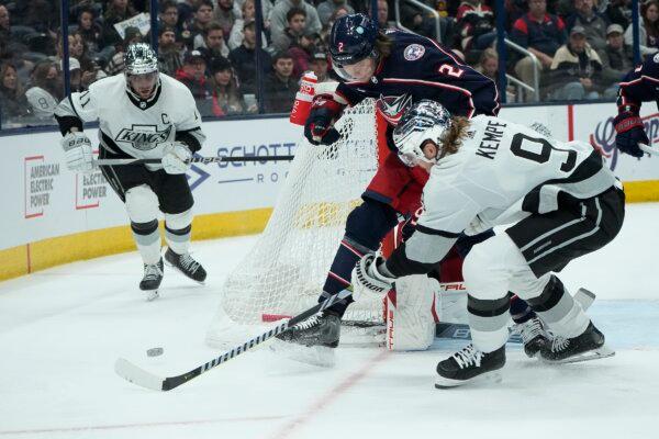 Los Angeles Kings' Adrian Kempe (9) passes to teammate Anze Kopitar (11) in front of Columbus Blue Jackets' Andrew Peeke (2) in the first period of an NHL hockey game in Columbus, Ohio, Dec. 5, 2023. (Sue Ogrocki/AP Photo)