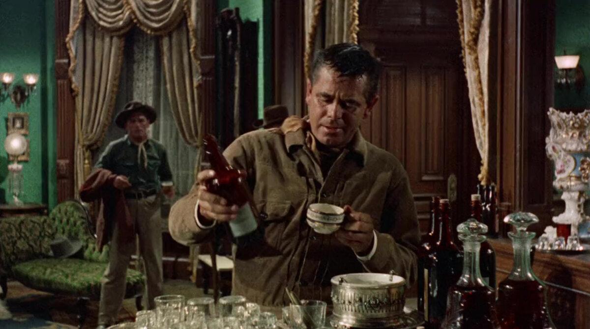 Tom Reese (Glenn Ford) secures some hotel whiskey after coming in from the dusty trail, in “Cowboy.” (Columbia Pictures)