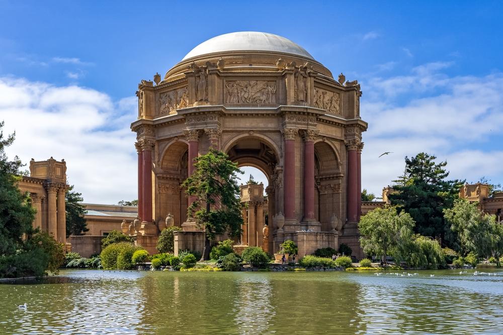 A view of the rotunda and pergola shows an ornamental façade and statues around the perimeter of the dome, above a series of arches balanced by pairs of Corinthian columns. Greenery at the base gives scale to the structure's impressive size. (Gilberto Mesquita/Shutterstock)