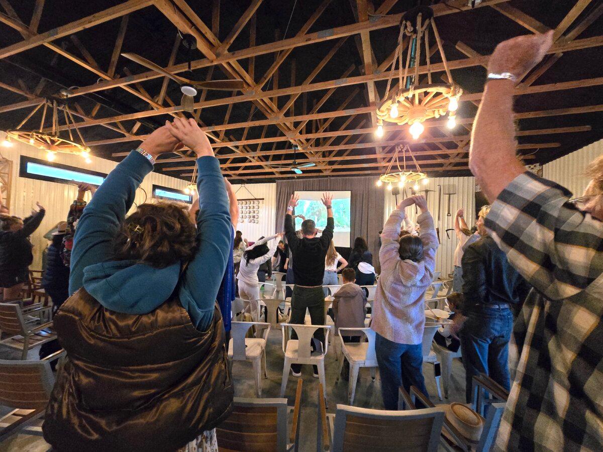 Visitors do the morning stretch during Confluence 2024 in Bandera, Texas, on April 5, 2024. (Allan Stein/The Epoch Times)