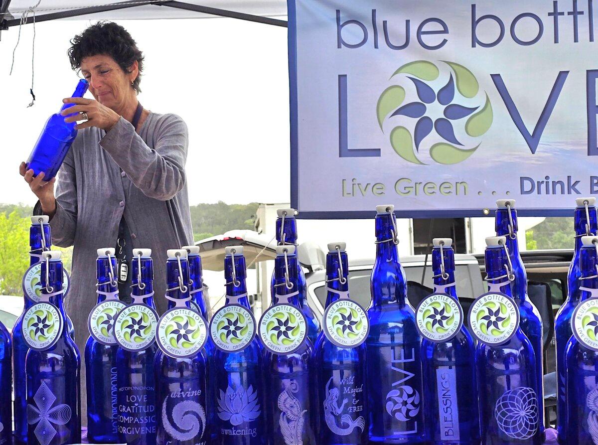 Kayden Radhe of Blue Bottle Love displays a glass water bottle during Confluence 2024 in Bandera, Texas, on April 5, 2024. (Allan Stein/The Epoch Times)