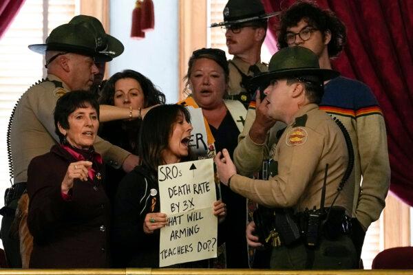 People in the gallery of the House chamber are removed by state troopers after a bill allowing some teachers to be armed in schools passes during a legislative session in Nashville, Tennessee on April 23, 2024. (AP Photo/George Walker IV)