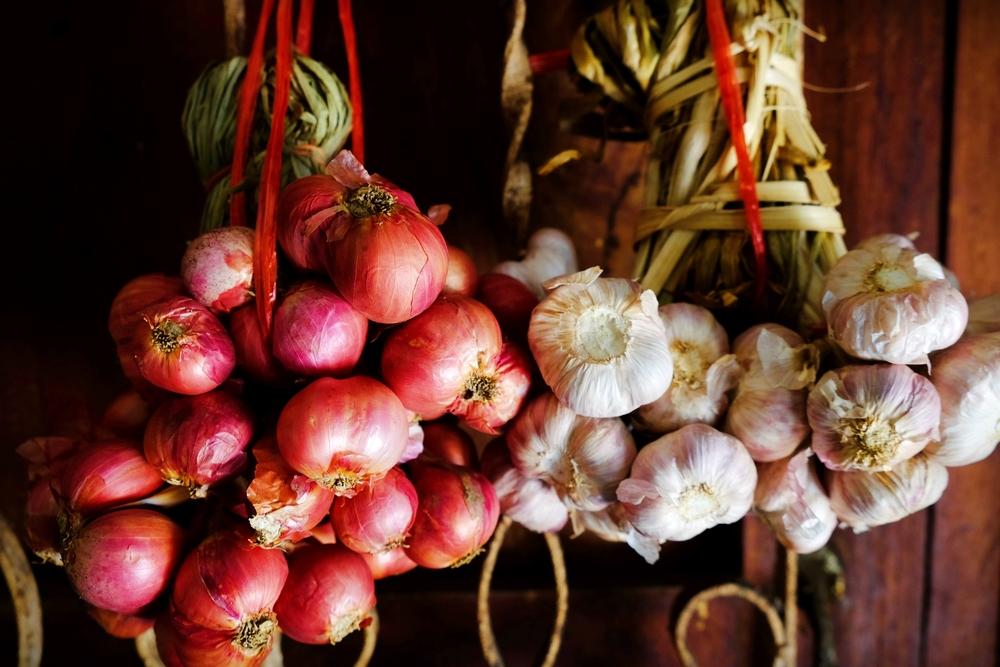 Onions and garlic can be hung to dry in preparation for winter storage. (ratchakon/Shutterstock)
